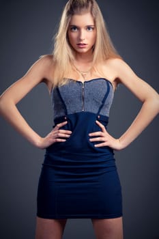 Beautiful and attractive woman posing on studio over a dark gray background