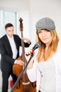 Woman next to microphone and man with contrabas