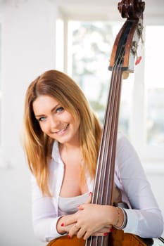 Young woman hold on contrabass with both hands