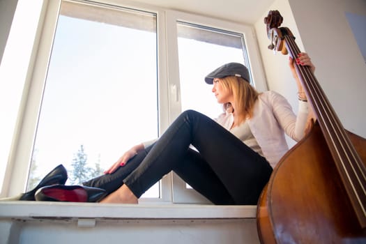 Young woman on windowsill looking outdoor on street