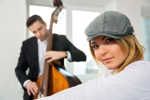 Beautiful woman face and contrabas player on backbround