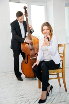 Woman on wooden chair singing song in microphone