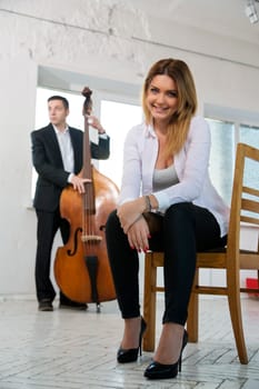 Beatiful woman smile at camera and contrabas player