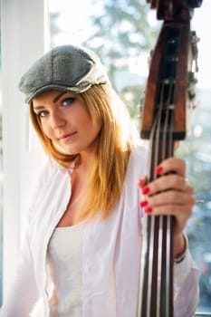 Charming woman with hat and part of contrabass