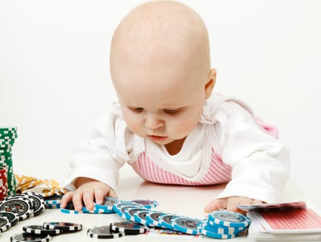 beautiful half-year-old baby playing with playing chips