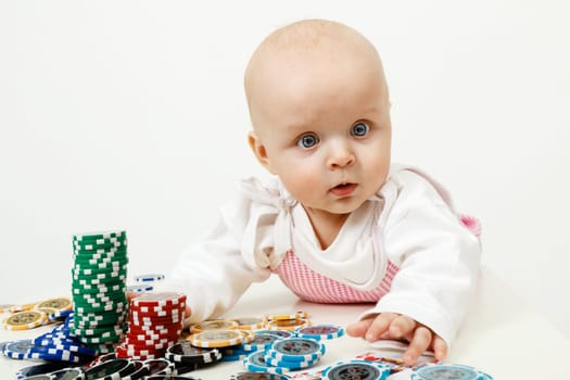 beautiful half-year-old baby playing with playing chips