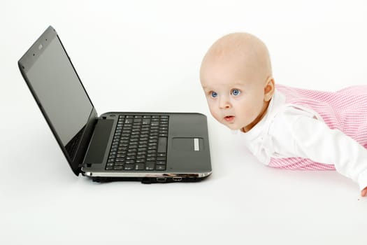 lying on the floor a beautiful baby girl with black laptop