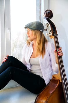 Charming woman with contrabas thinking about something seriously