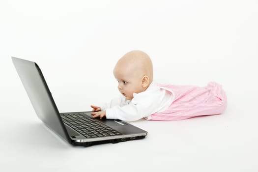 lying on the floor a beautiful baby girl with black laptop