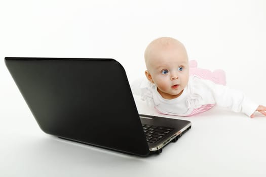 lying on the floor a beautiful baby girl with black laptop