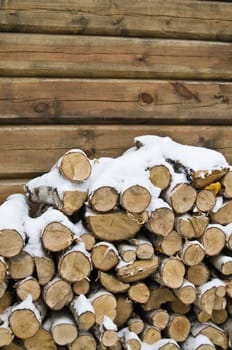 Birch fire wood at a wall of the house in winter