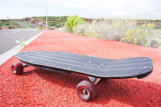 Vintage Style Longboard Black Skateboard on an Empty Asphalt Desert Road