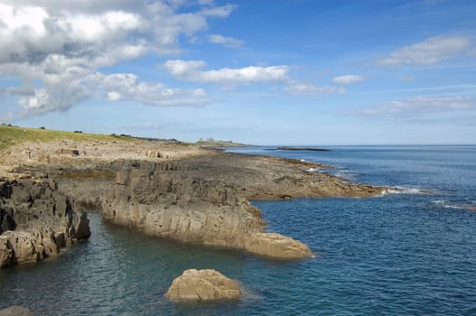 Northumbrian coastline near Craster with the ruins of Dunstanburgh Castle in the distance