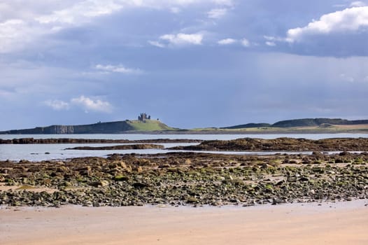 Dunstanburgh castle from beach of embleton bay