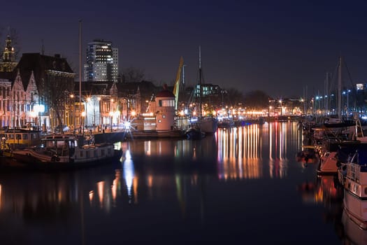 Harbour by night with old fishingships, yachts and reflection of lights