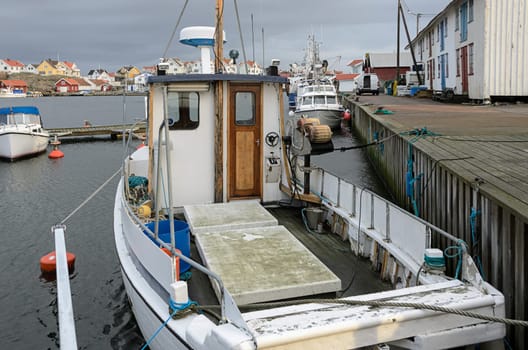 a lone fishing boat in its harbor a winter day