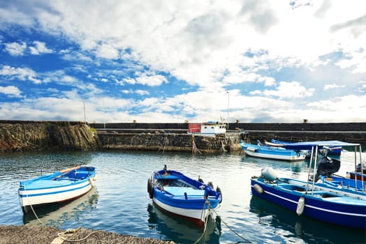 Fishing Boat, color blue white, moored along the quay on a cloudy day
