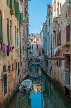 Bridge, boat and a canal in Venice, Italy.
