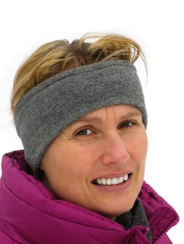 Young lady with headband in winter looks thoughtfully into the camera.