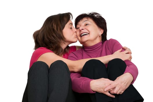 Portrait of daughter kissing happy senior mother - isolated on white