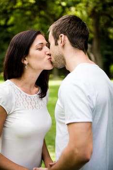 Young happy couple kissing  - outdoor lifestyle portrait