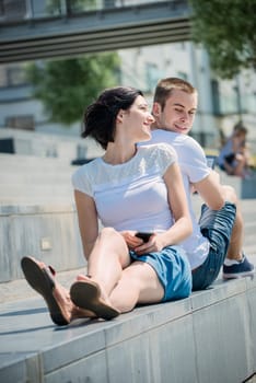 Young couple in street - woman with smartphone, man with tablet