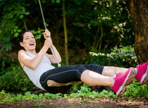 Young woman swinging on seesaw outdoor in nature