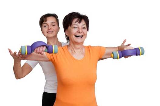 Smiling senior fitness woman exercising with barbells assisted by coach - isolated on white