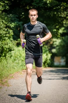 Jogging in nature - young man training with barbells
