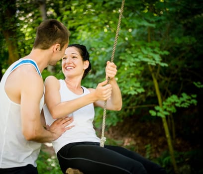 Young sport couple having fun - swinging on seesaw
