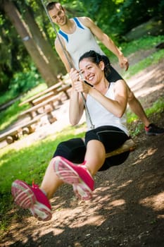 Young sport couple having fun - swinging on seesaw