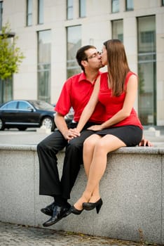 Lifestyle photo of young kissing business people outdoor in street