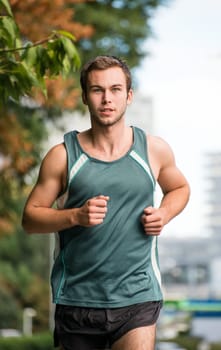 Healthy lifestyle - young attractive man jogging in park