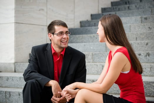 Colleagues - young business people having conversation sitting on stairs