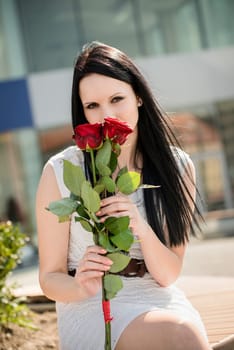 Young beautiful woman with red roses - outdoorf lifestyle portrait