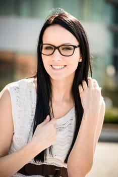 Young beautiful woman with glasses holding hair