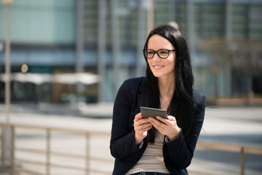 Young woman reading book on electronic book-reader
