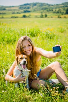 Young woman taking photo of herself and her pet with mobile phone camera