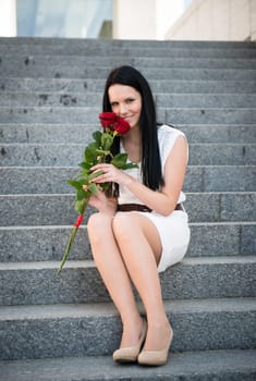Young beautiful woman with red roses - outdoorf on stairs