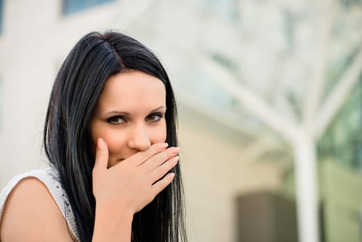 Young beautiful woman covering mouth with hand