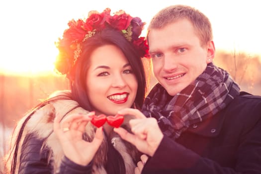 Young couple are holding pair of hearts as a symbol of their love