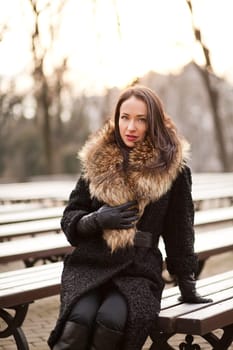 Young professional lady in the park is enjoying winter