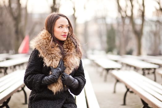 Young professional lady in the park is enjoying winter