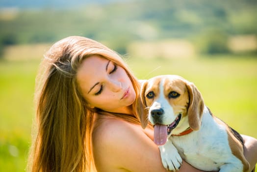 Teen girl holding her pet (beagle dog) - outdoor in nature