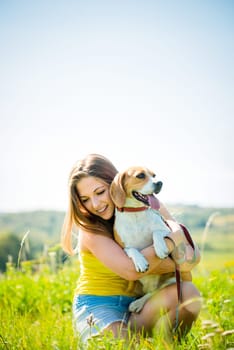 Portrait of teen girl with her beagle dog - outside in grass