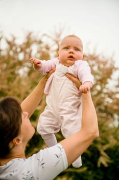 Mother lifting her beautiful baby - outdoor in nature