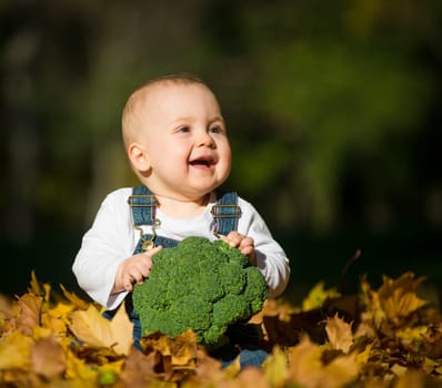 Beautiful baby girl eating food outdoor in nature