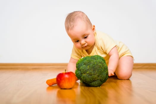 Baby exploring fruit and vegetables - healthy lifestyle