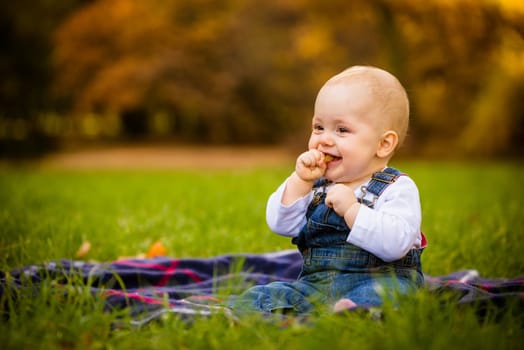 Beautiful baby girl eating food outdoor in nature