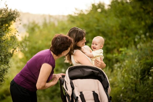 Happy together - grandmother with her daughter and her granddaughter outdoor in nature